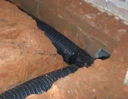 A drain installed at the foundation of the crawl space to lead water away from the structure